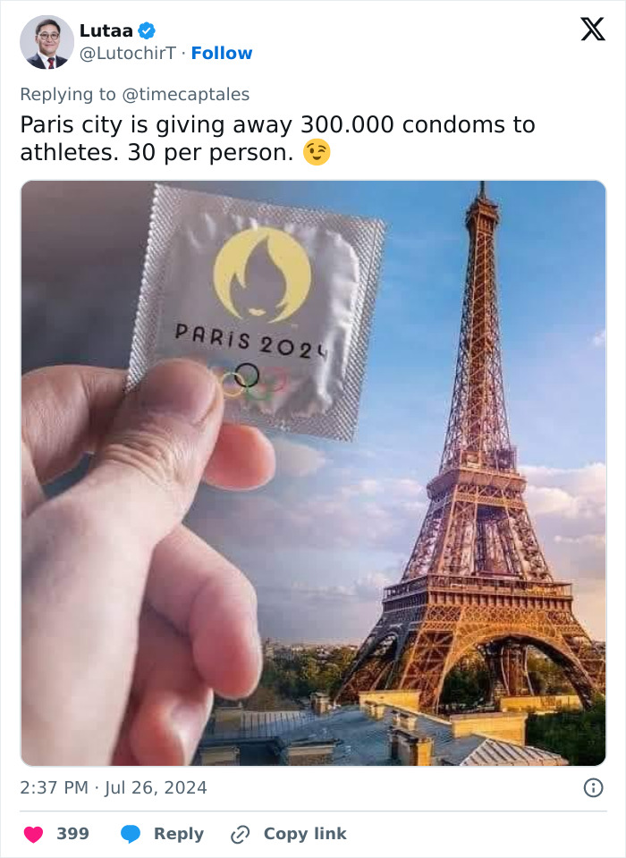 Hand holding a Paris 2024 Olympic c****m packet with the Eiffel Tower in the background, highlighting athlete rubber shortage.