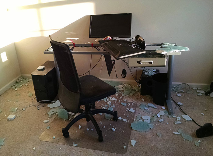 Home office with broken desk and scattered debris illustrating sibling conflict and parenting consequences aftermath.