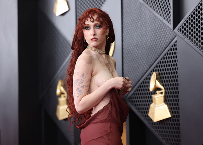 Chappell Roan at the Grammys 2026, bold look analyzed by body language expert in a striking maroon dress and gold choker.