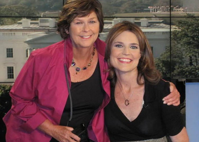 Two women smiling together indoors with a blurred background discussing hostage negotiator theory.