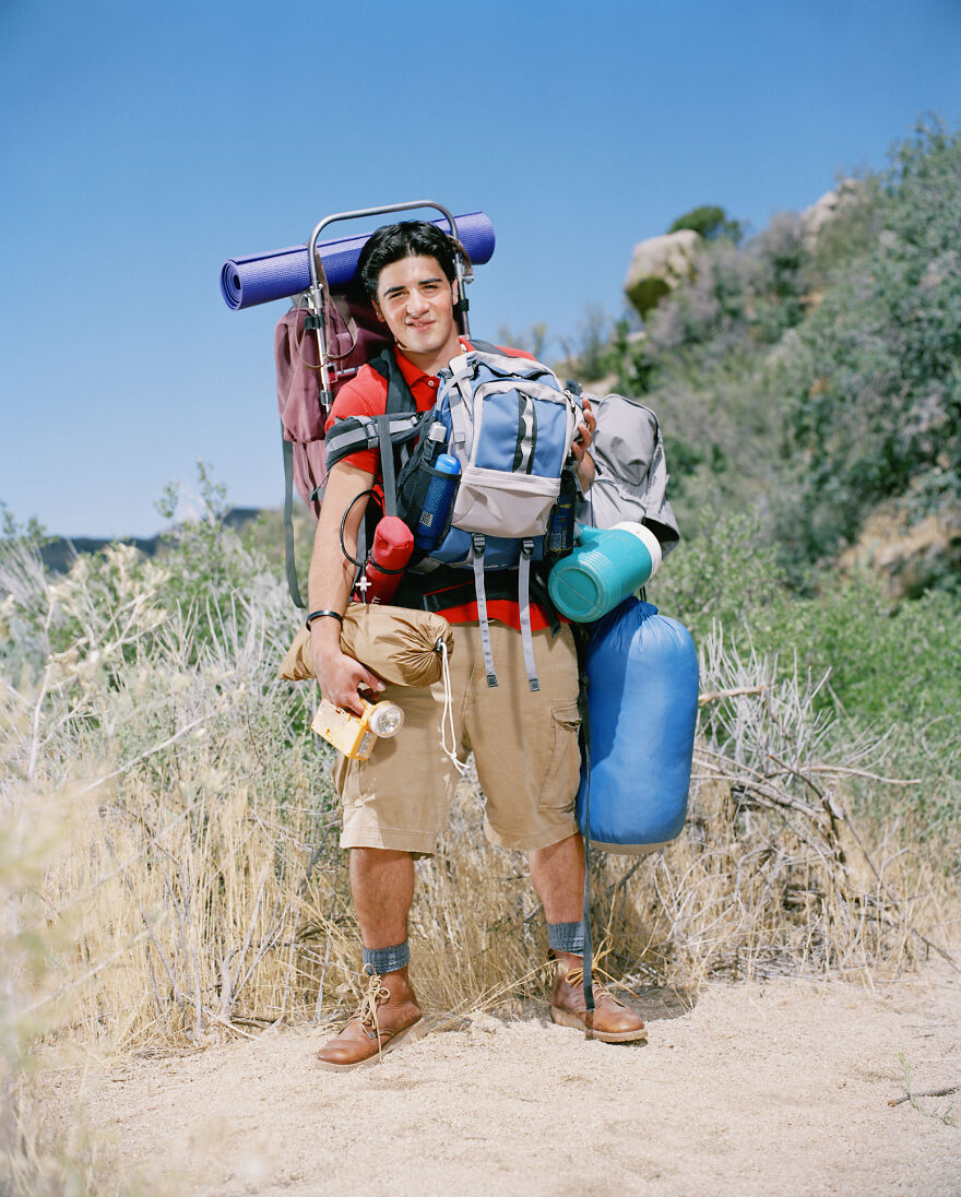Young man hiking outdoors with oversized backpack and camping gear, illustrating pet peeves about overpacking.