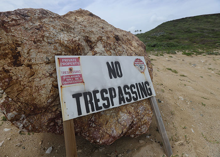 No trespassing sign on rocky terrain at Epstein Island, related to mobile game players catching Pok&eacute;mon there.