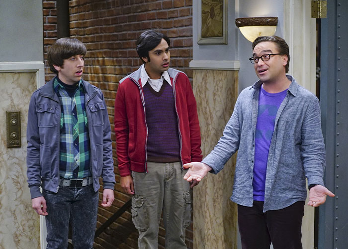 Kunal Nayyar from The Big Bang Theory reacting with co-stars in a hallway scene from the TV show.