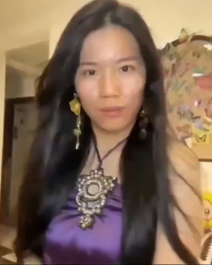 Beauty influencer with long black hair and statement jewelry, revealing true face after filter fail causing follower loss.