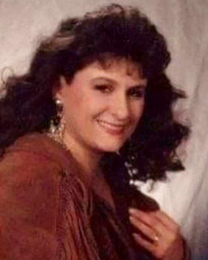 Smiling woman with curly hair and earrings, representing the mom who vanished 25 years ago and was recently arrested.