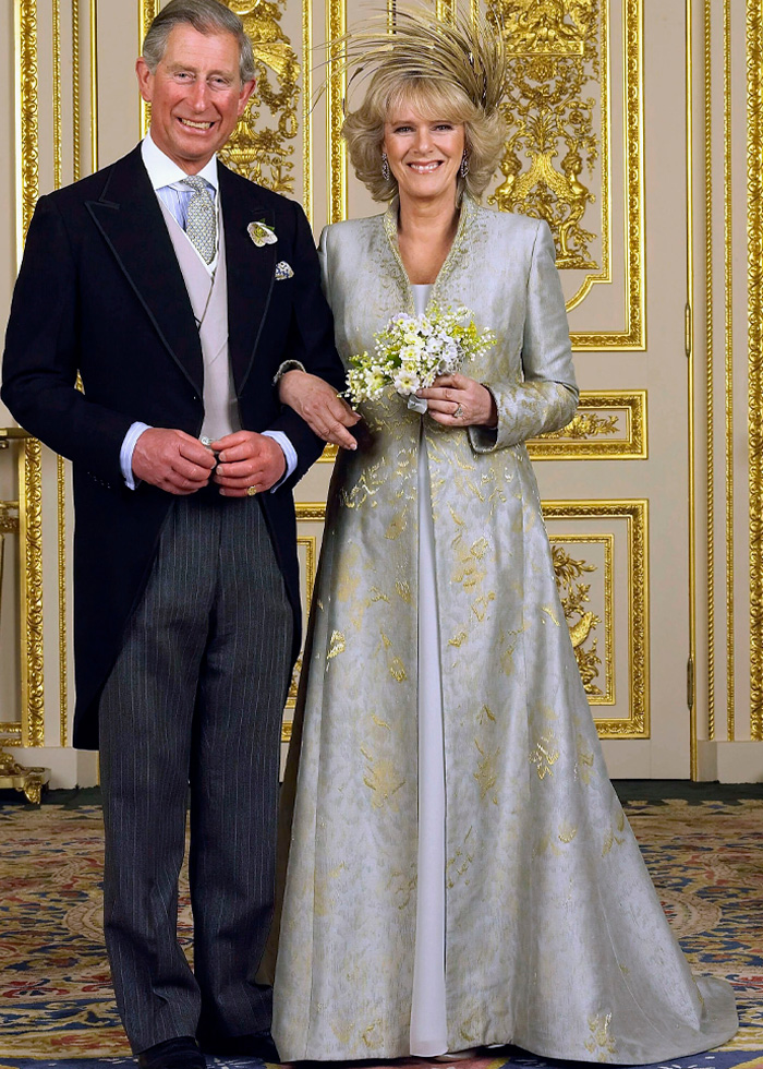 Prince Charles and Camilla Parker Bowles posing in formal attire with royal wedding dresses featured in elegant setting.