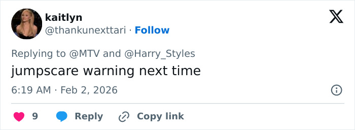 Tweet replying to Harry Styles with a jumpscare warning, highlighting backlash over Harry Styles outfit at 2026 Grammys.