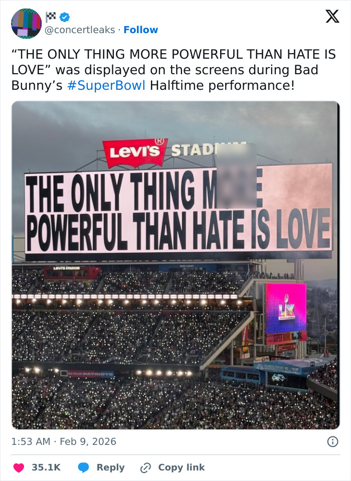 Large stadium screen displaying the message powerful than hate is love during Bad Bunny's Super Bowl 2026 halftime show.