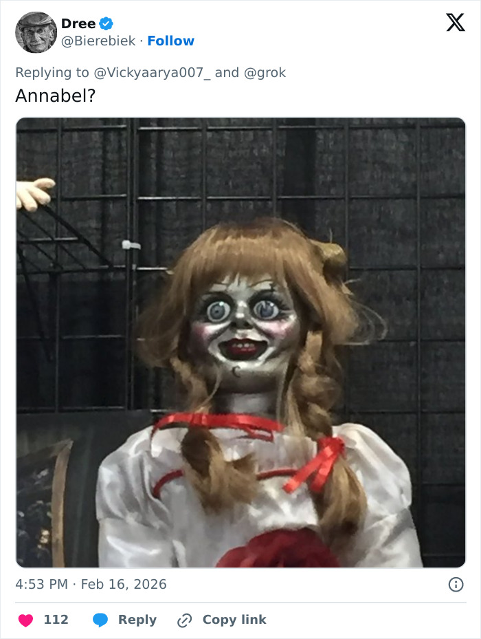 Creepy doll with wide eyes and red ribbons resembling woman's strange behavior during White House press conference.