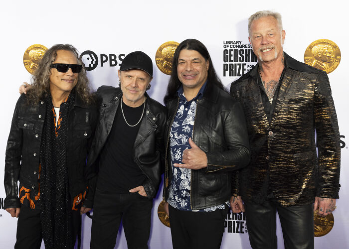 Rock band members posing together at an event, representing the luxury and custom $2.5 million mobile mansion lifestyle.