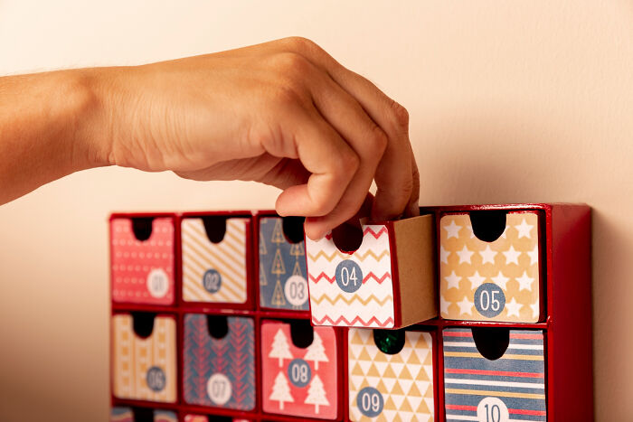 Hand removing drawer from a decorative set of small numbered boxes, symbolizing toxic workplace moments and employee experiences.