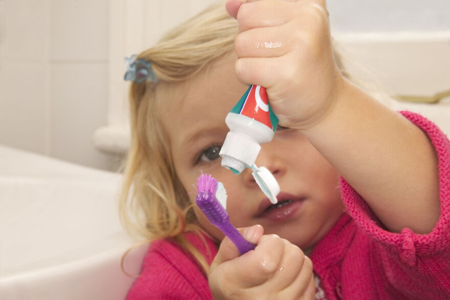 Young child squeezing too much toothpaste onto toothbrush, illustrating common pet peeves that instantly divide a room.