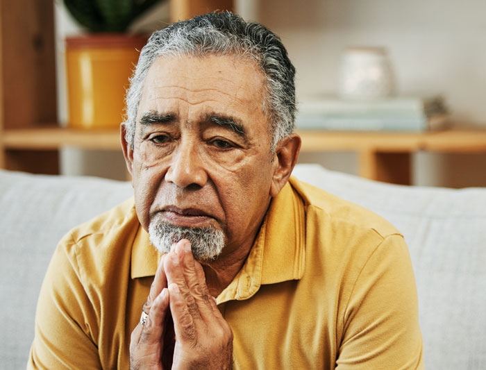 Older man looking concerned and thoughtful in a living room, reflecting on a surprising roommate&rsquo;s parents babysitter situation