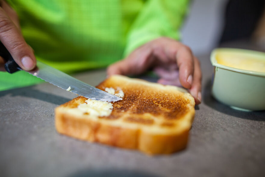 Spreading butter unevenly on toasted bread, illustrating a common pet peeve that can divide a room.