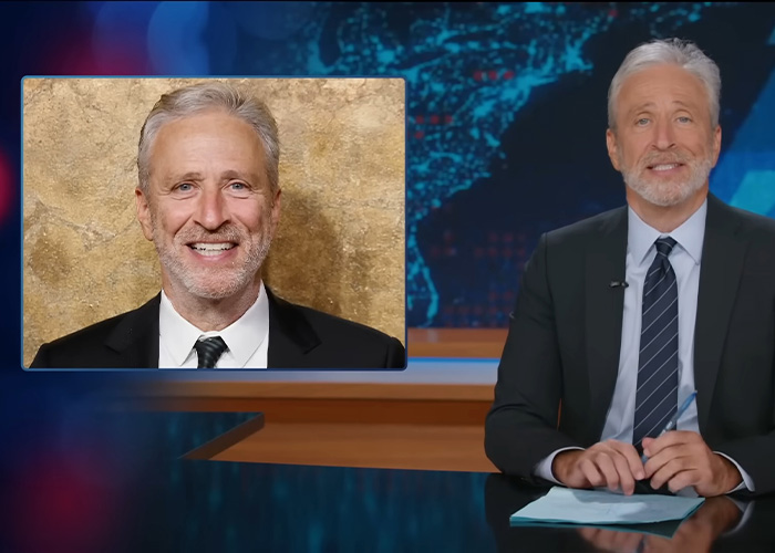 Comedian Jon Stewart addressing Epstein files news in a television studio, wearing a suit and tie.