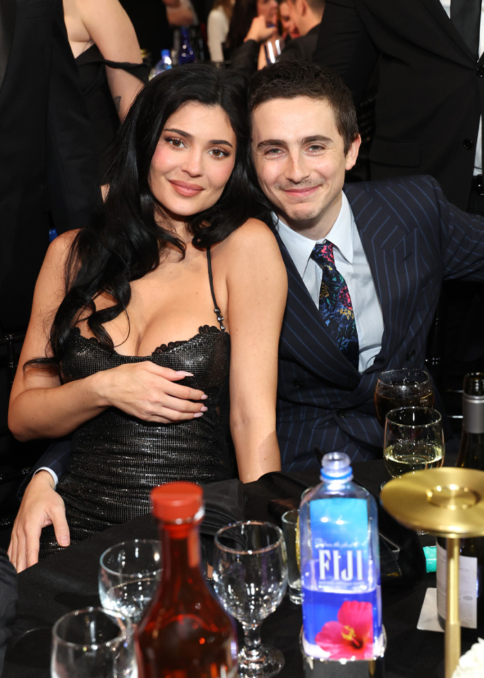 Timoth&eacute;e Chalamet and Anamaria Vartolomei smiling at an event, sparking conspiracy theories about their hotel appearance.