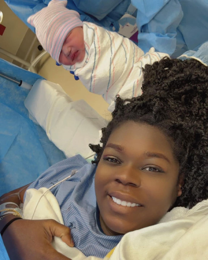 Newborn baby wrapped in hospital blanket with smiling surrogate mother after birth, related to surrogate suing couple news.