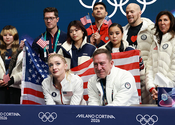 Amber Glenn with team members at Milano Cortina 2026 event, showing support amid backlash and threats over beliefs