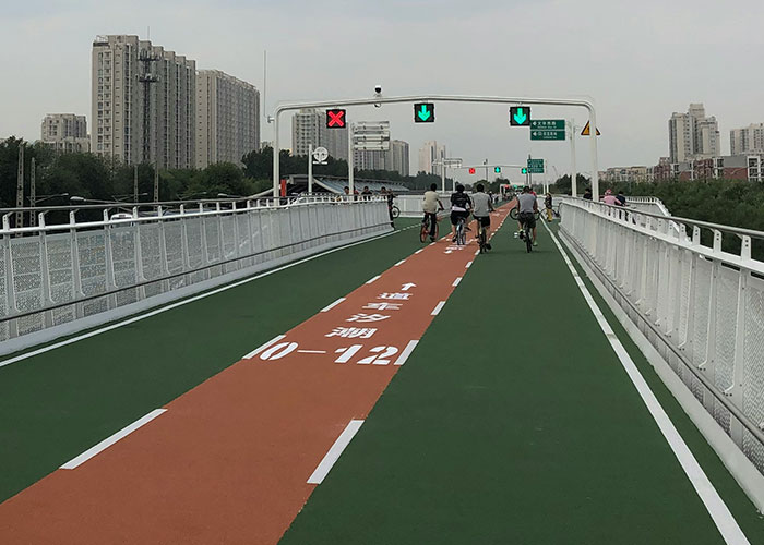 Bike lane on an urban bridge with clear traffic signals, showcasing innovative infrastructure that just makes sense in some countries.