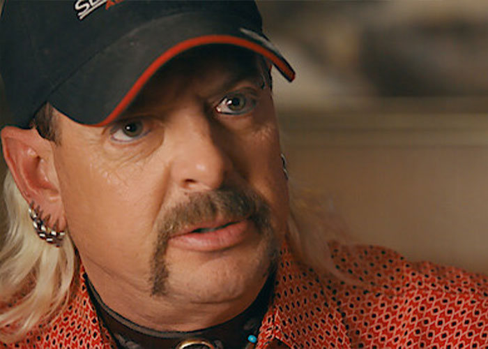 Joe Exotic wearing a cap and patterned shirt, looking surprised while discussing Epstein files on the internet.