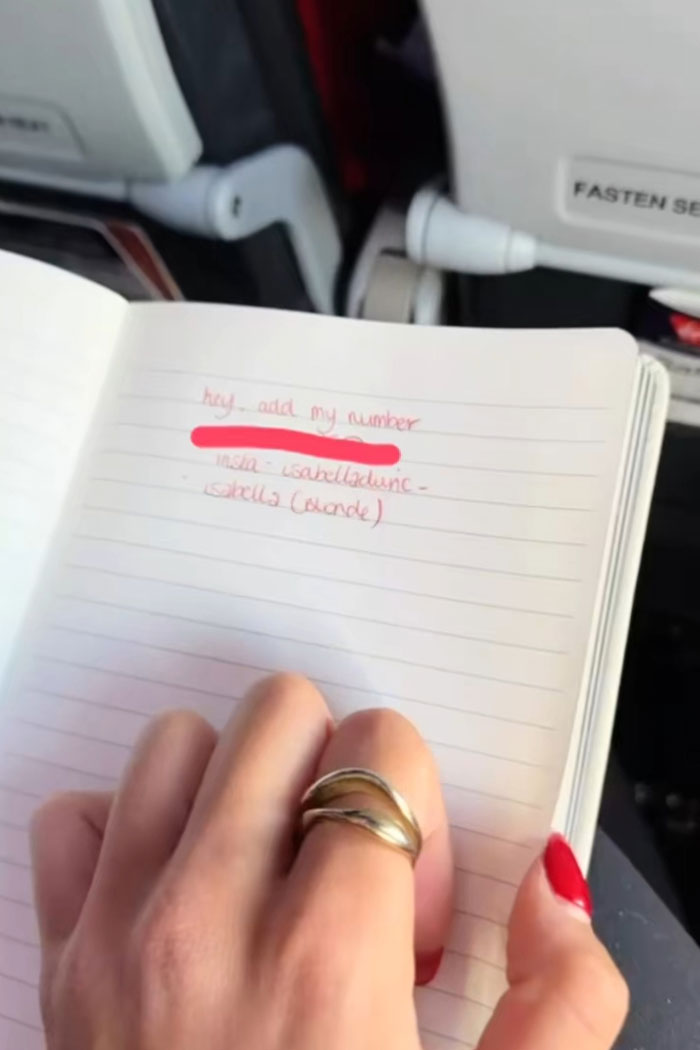 Hand holding notebook with a love note written by an Australian woman on a flight, going viral for cute guy message. Hand holding notebook with a love note written by an Australian woman on a flight, going viral for cute guy message.