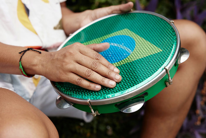 Person playing a tambourine with a Brazilian flag pattern, demonstrating an effective way to deal with lost children.