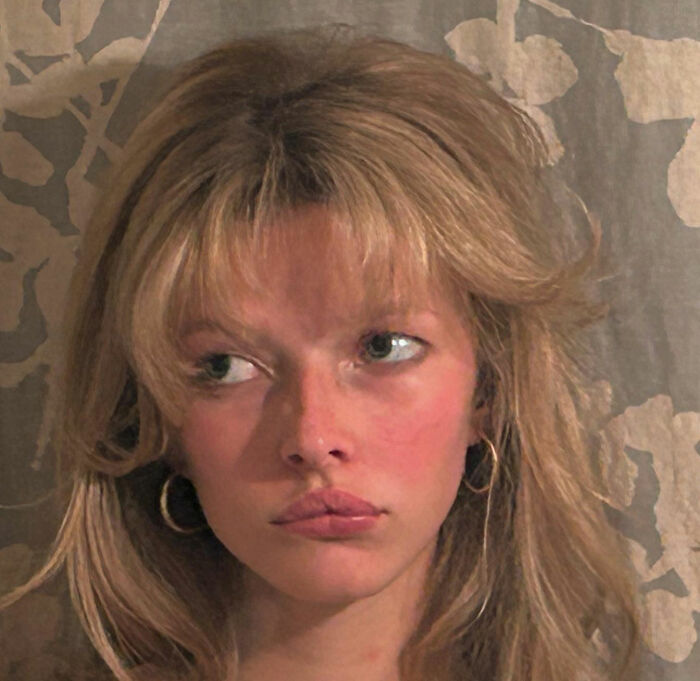 Apple Martin, Gwyneth Paltrow's nepo baby, with natural makeup and casual hairstyle against a floral patterned background.