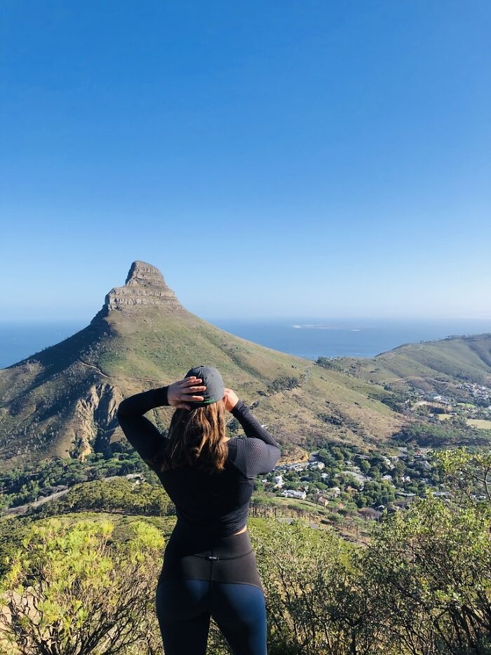 Woman standing on a hill overlooking a mountain, embracing the experience of living out of a suitcase for years. Woman standing on a hill overlooking a mountain, embracing the experience of living out of a suitcase for years.
