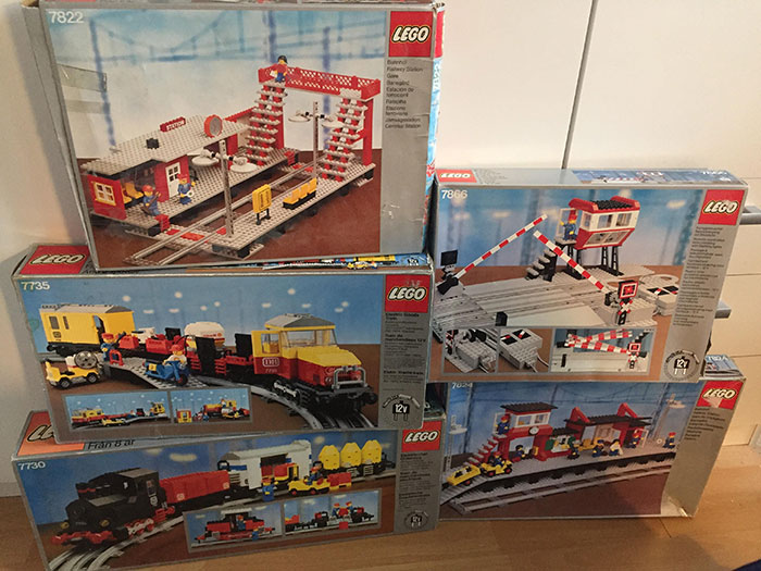 Stacks of expensive Lego train sets displayed in boxes, linked to cheating ex-wife's boyfriend stealing incident.