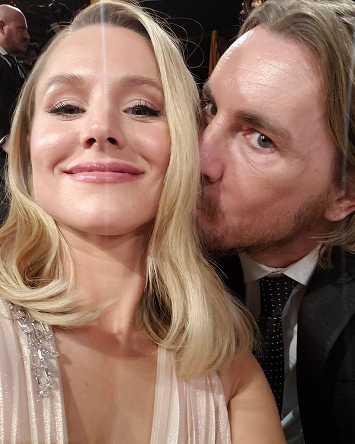 Dax Shepard and Kristen Bell close-up selfie at an event, with Dax giving a kiss on Kristen's cheek.