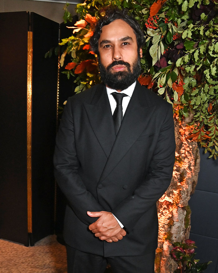 Kunal Nayyar in a black suit standing near a floral arrangement reflecting on his GoFundMe revelation and public response.