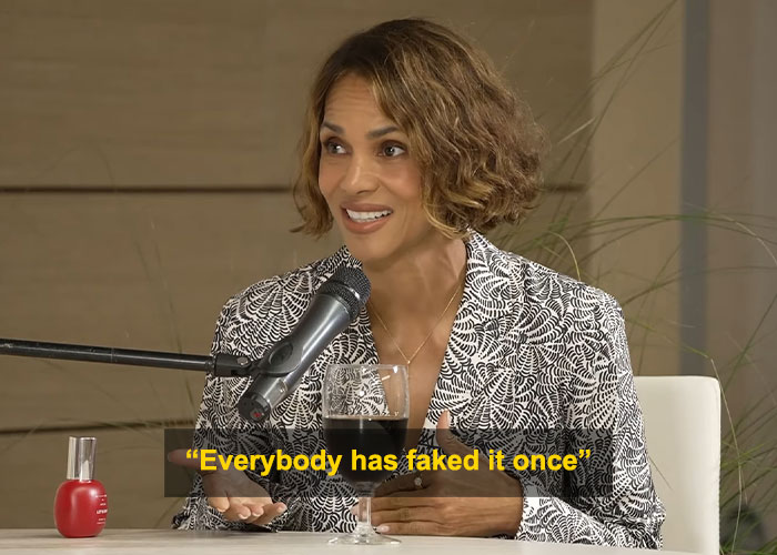Halle Berry speaking into a microphone, smiling and sharing insights about intimacy during an interview session.