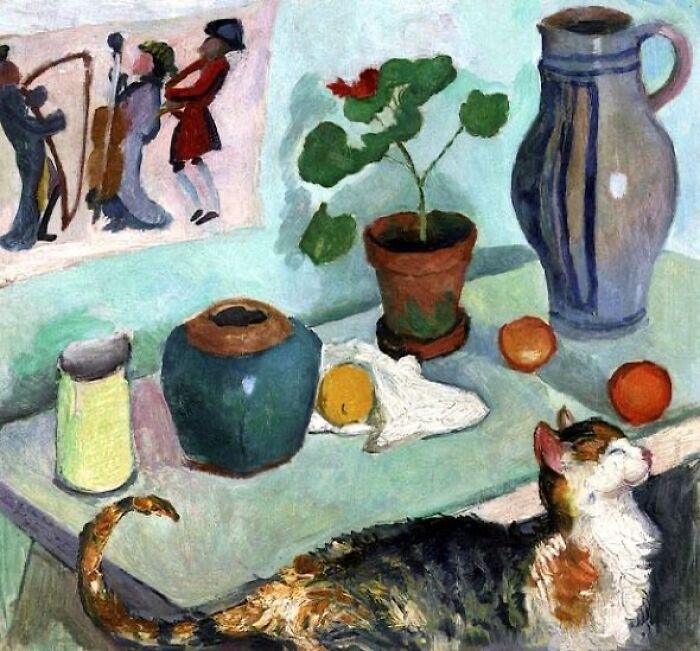 Calico cat resting near still life painting with vases, fruit, and a potted plant in cat-themed artwork.
