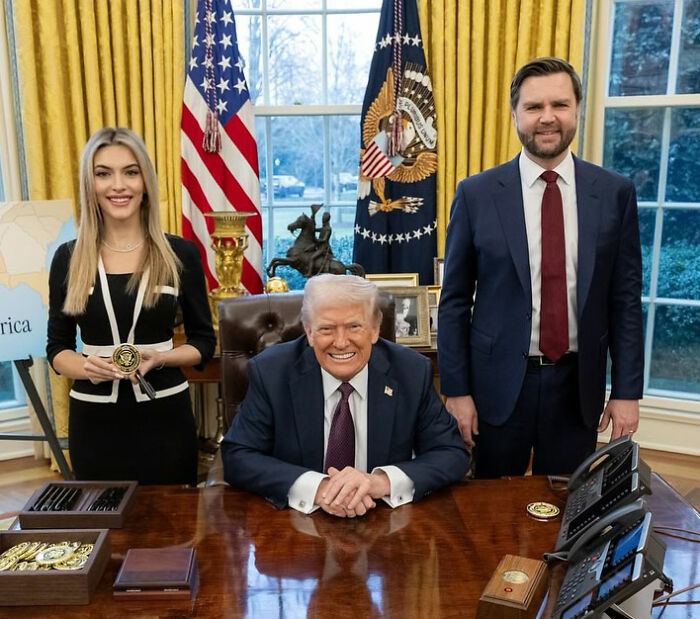 MAGA influencer Emily Austin posing with former President Trump in the Oval Office, smiling and holding a medallion.