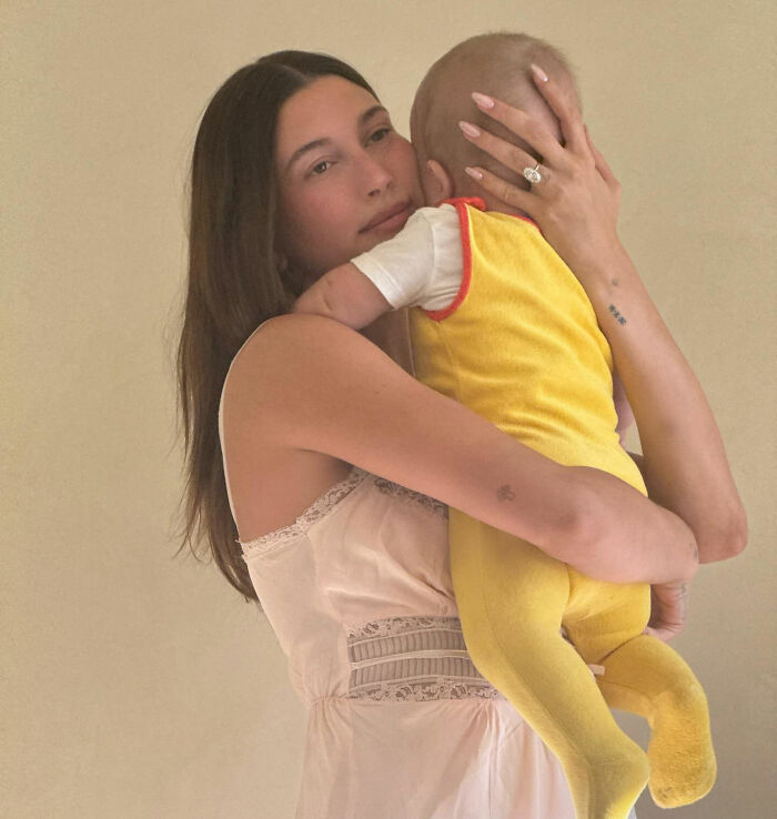 Hailey Bieber holding a baby, showing a tender moment amid fans crying foul over Justin Bieber at the Grammys.