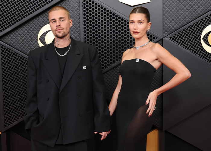 Justin Bieber and partner wearing black, posing on the red carpet as body language expert decodes tense behavior. Justin Bieber and partner wearing black, posing on the red carpet as body language expert decodes tense behavior.