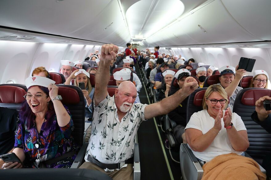 Passengers celebrating on an airplane, highlighting common pet peeves that can divide a room during travel experiences.