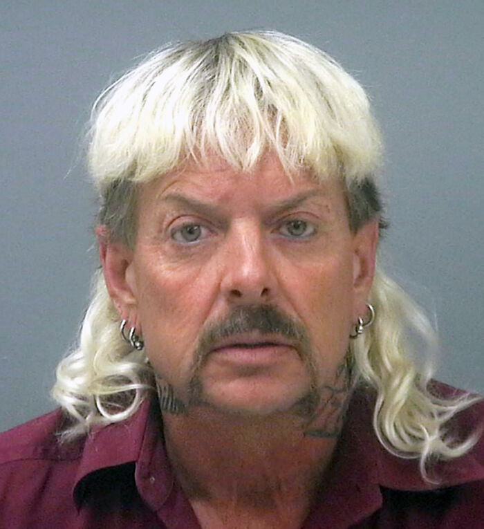 Joe Exotic with bleached hair and earrings in a close-up portrait related to Epstein files breaking the internet.