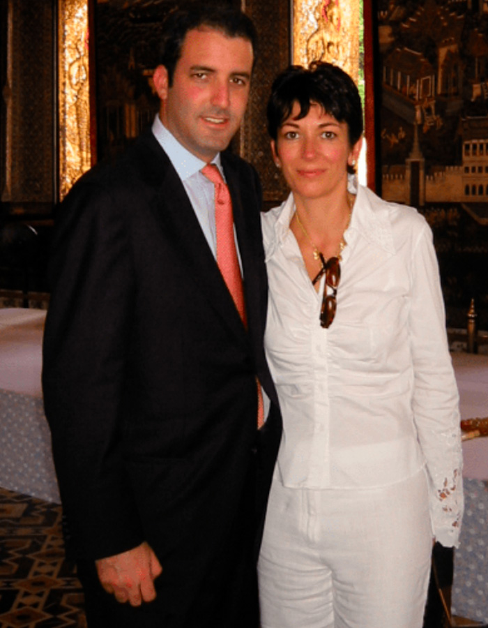 Ghislaine Maxwell standing next to a man in formal attire, with an ornate background and soft indoor lighting.