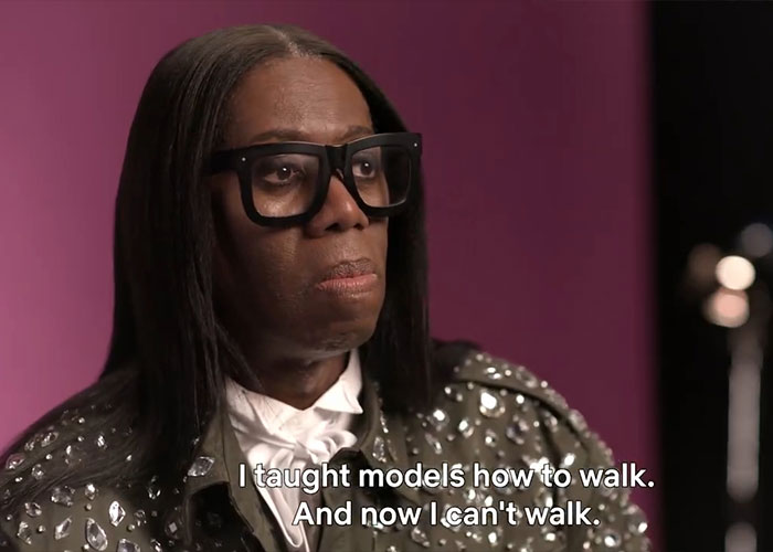 ANTM star J Alexander wearing glasses and a studded jacket, sharing his stroke experience in an interview setting.