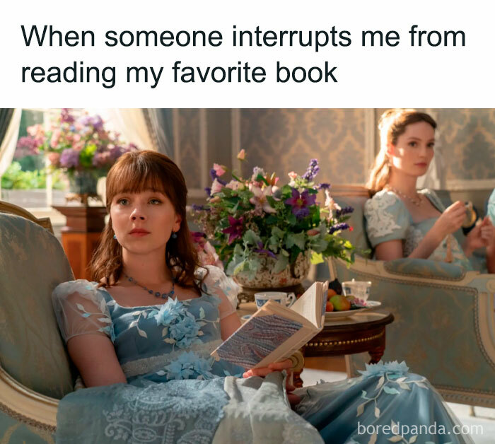 Scene from Bridgerton with a woman in a blue dress reading a book, expressing frustration at being interrupted.