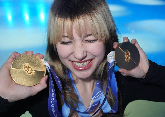 Young athlete holding Olympic gold and bronze medals, highlighting health experts' warnings for fans copying viral looks.