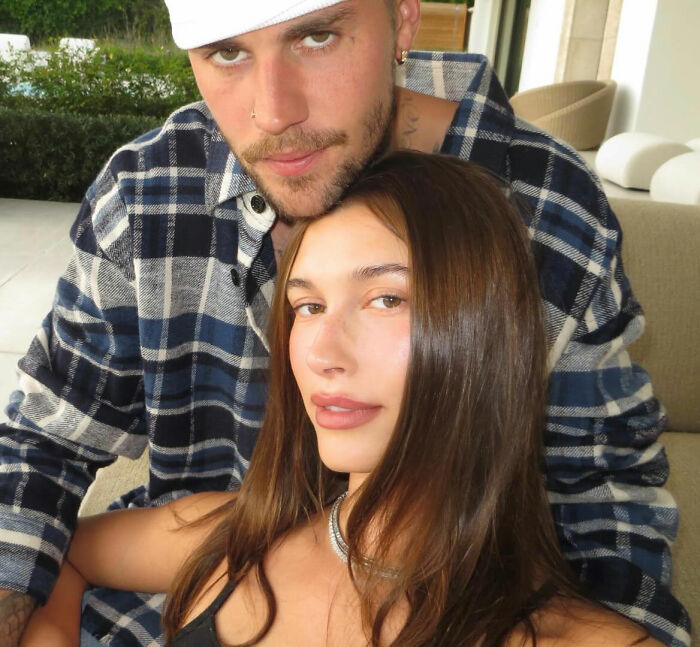 Justin Bieber and Hailey posing closely indoors, fans react after Bieber exits Grammys with another woman.