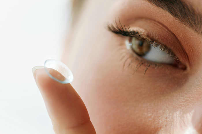 Close-up of a healthcare worker holding a contact lens on finger, illustrating insights healthcare workers share after experience.