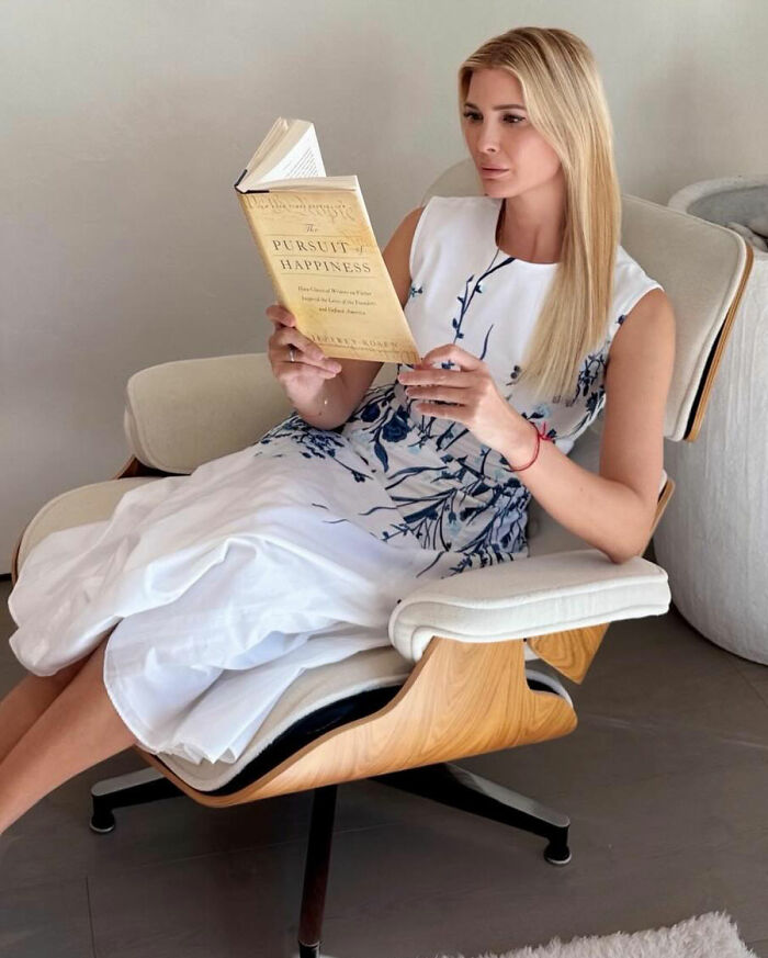 Ivanka Trump sitting in a chair reading a book, showing her transformation and style after Lunar New Year&rsquo;s post.
