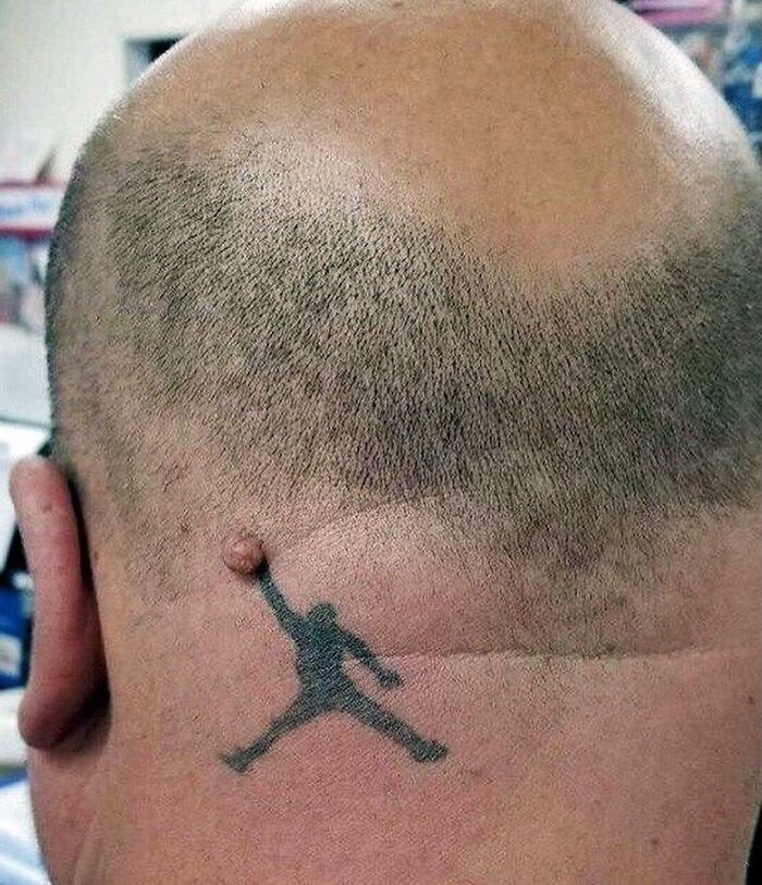 Bald man with a tattoo of a basketball player using a skin bump as the basketball in a weirdly hilarious image.