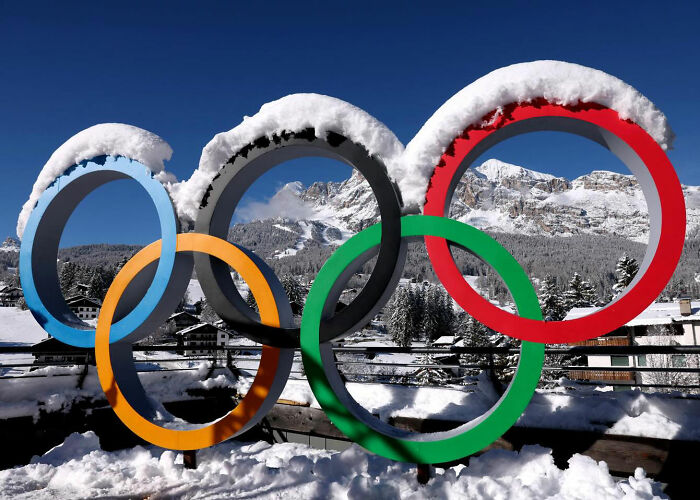 Olympic rings covered with snow at a Winter Olympics venue highlighting rule change after manhood scandal.