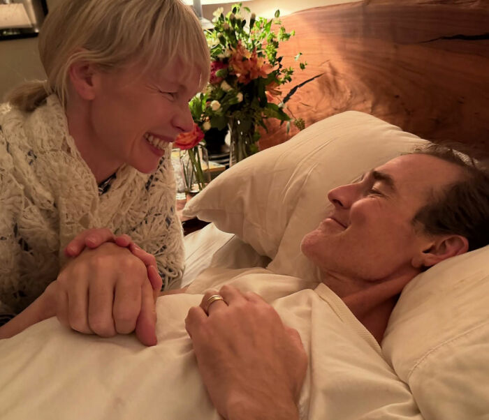 James Van Der Beek resting in bed, holding hands with a smiling woman, capturing final days shared by his friends.