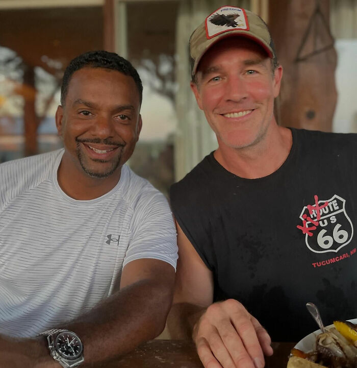 Two men smiling at a table, capturing a moment shared by James Van Der Beek&rsquo;s friends during his final days.