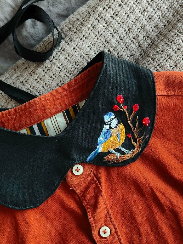 Beautiful embroidery creations of a bird on a branch with red berries on a black collar, perfect for an embroidery hobby.